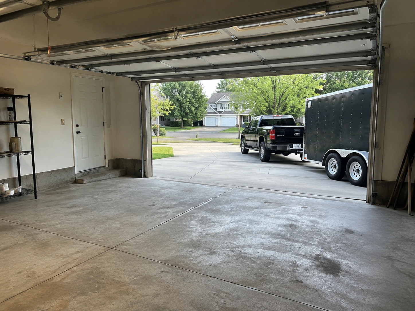 Example garage cleanout showing an empty garage with a pickup and enclosed trailer outside