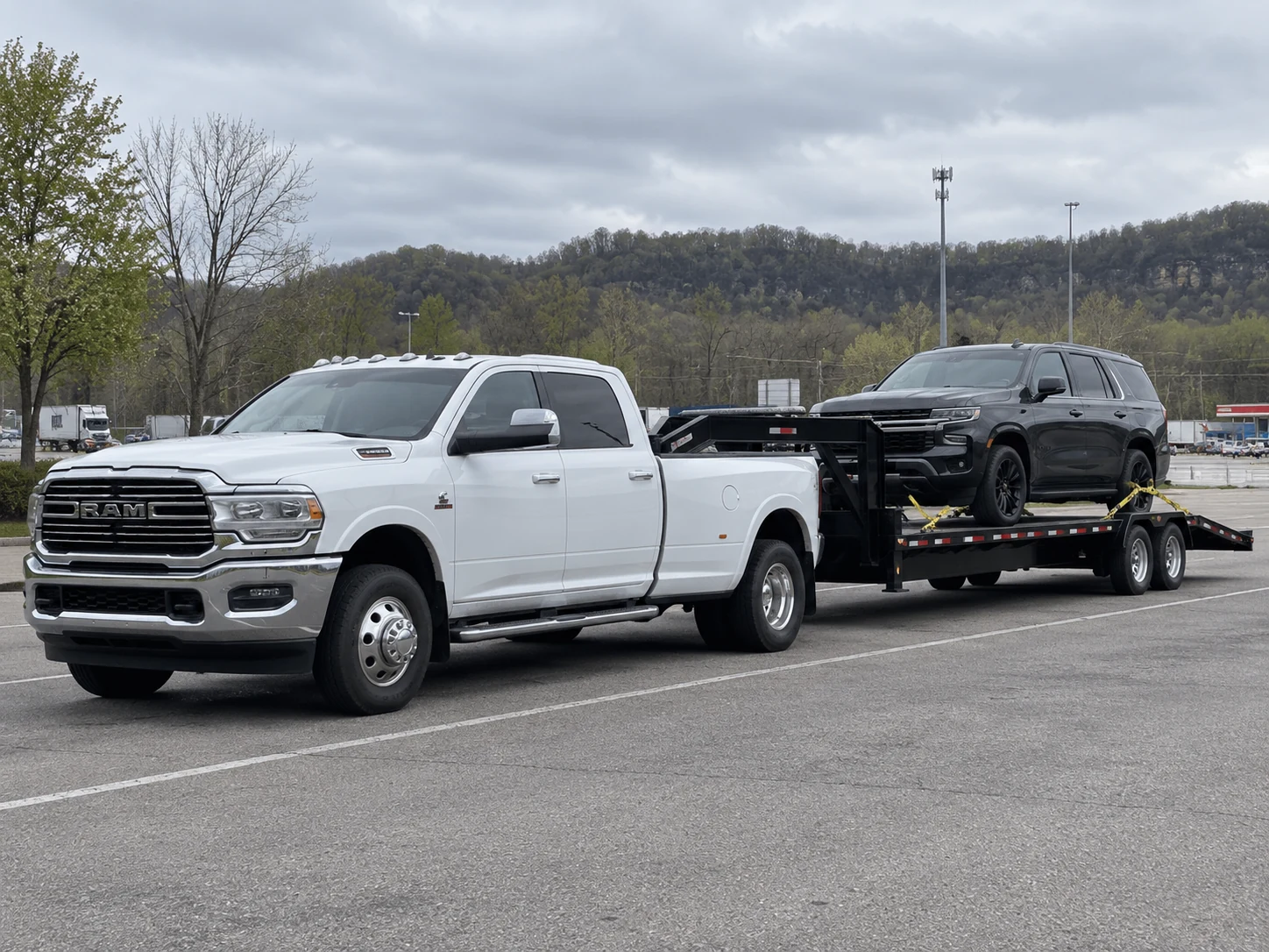 Example vehicle transport work showing a heavy-duty pickup hauling an SUV on a trailer